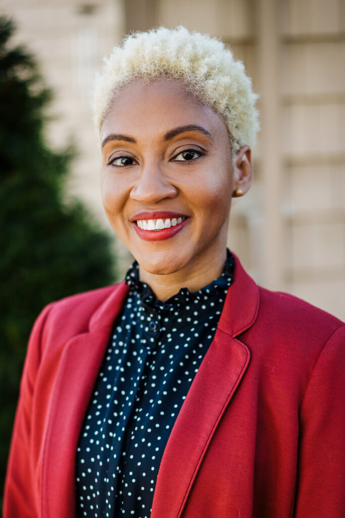 Professional woman in red blazer with natural joyful smile outdoor headshot northern New Jersey