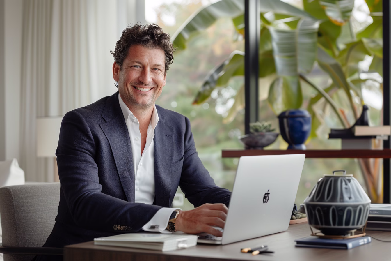 executive smiling at desk modern office by alex kaplan headshots