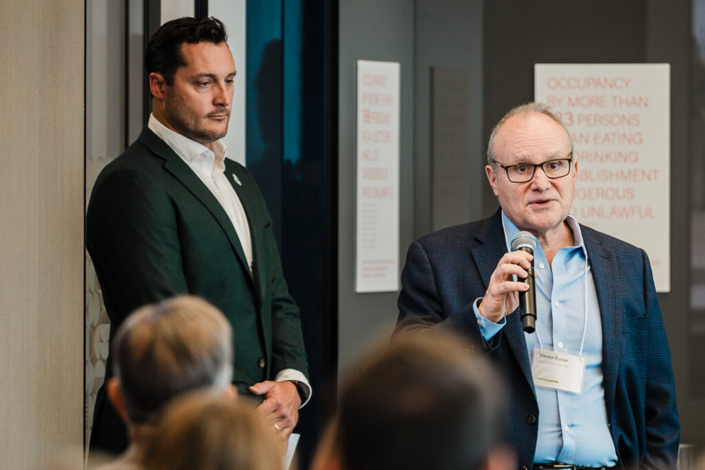 Speaker holding microphone during Climate Week NYC panel, captured by Alex Kaplan Photography.