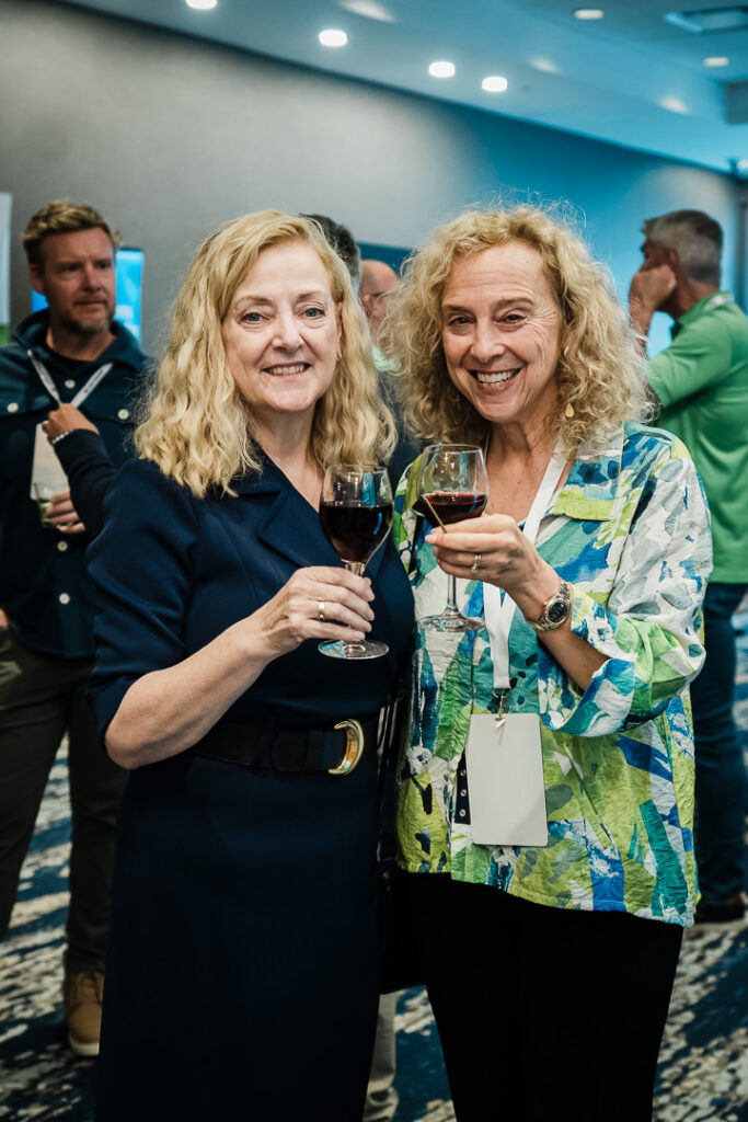 two-women-smiling-with-drinks-at-networking-reception-by-alex-kaplan-photography