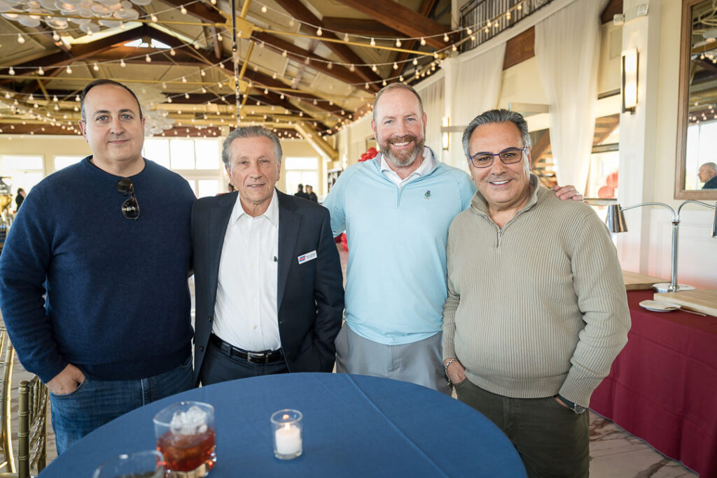 Four business professionals networking at Tilcon client appreciation day with NYC skyline visible