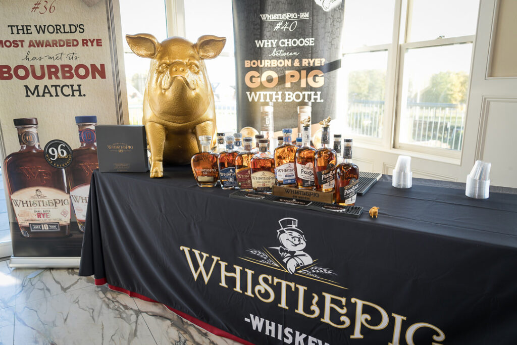 WhistlePig whiskey display with golden pig mascot and premium bourbon bottles at corporate event