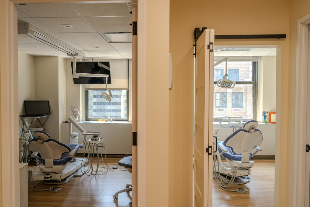 Architectural view showing two adjacent treatment rooms with sliding doors and consistent modern design throughout practice, Alex Kaplan commercial photography