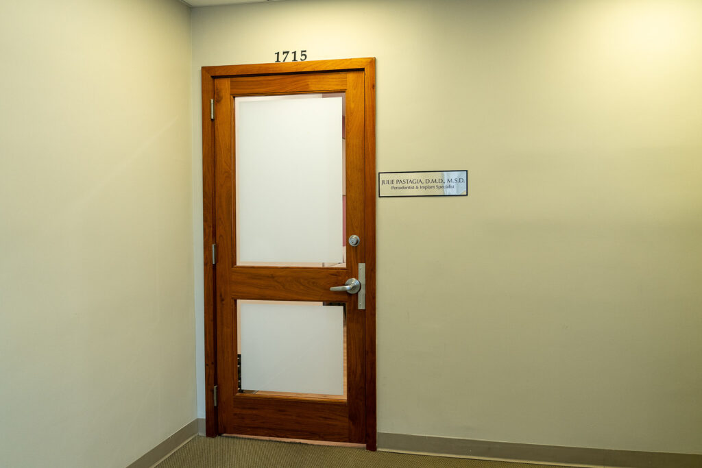 Modern dental office entrance featuring Suite 1715 door with frosted glass panels and warm wood tone, photographed by Alex Kaplan Photography in Midtown Manhattan