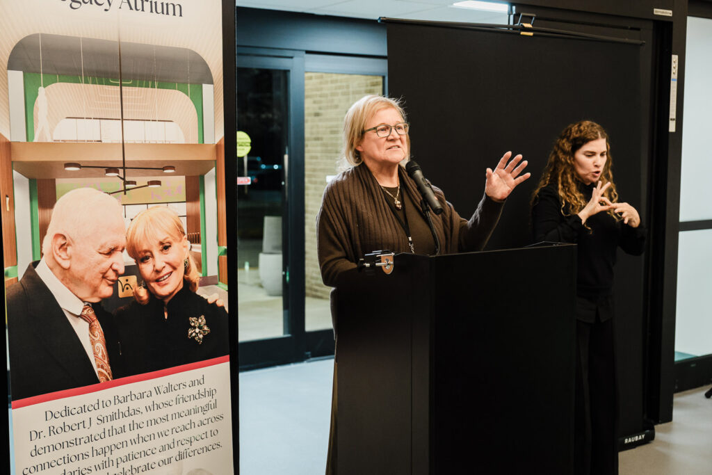 Speaker at Helen Keller National Center dedication with ASL interpreter during Walters-Smithdas Legacy Atrium unveiling