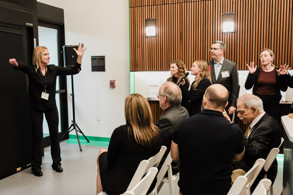 Speaker addressing seated audience during Walters-Smithdas Legacy Atrium dedication at Helen Keller National Center