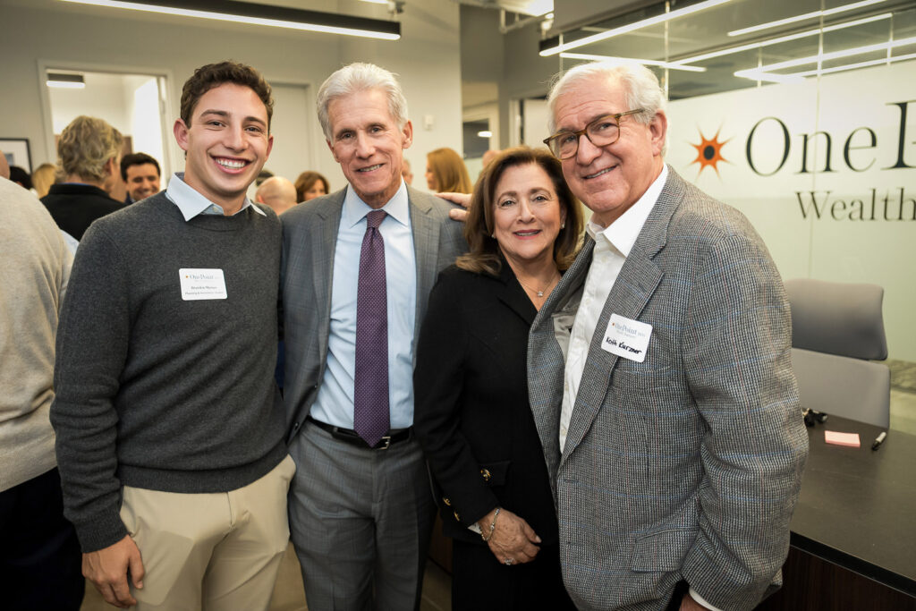Group of four professionals posing at OnePoint BFG wealth management event
