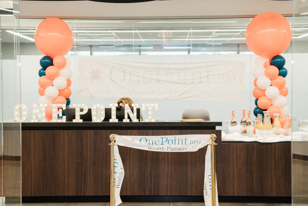 OnePoint BFG Wealth Partners branded reception desk with coral balloons at brand launch event in Parsippany, New Jersey