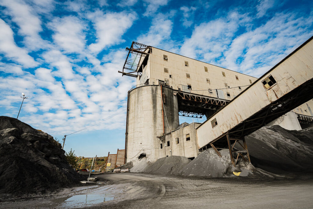 Concrete processing tower and elevated conveyor belts forming industrial skyline at Clinton Point Quarry facility.