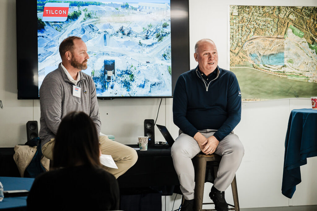 Tilcon CEO and executive in town hall Q&A format with quarry aerial imagery on screen behind them