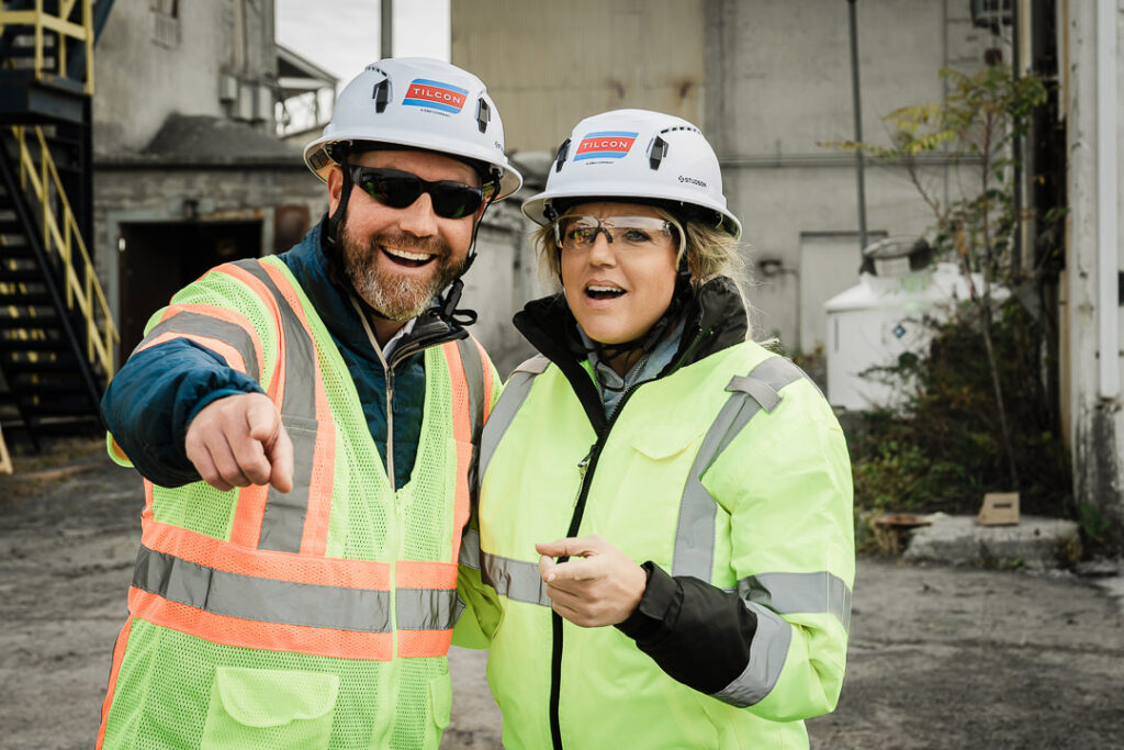 Two Tilcon executives in Tilcon branded hard hats smiling during Clinton Point Quarry site tour