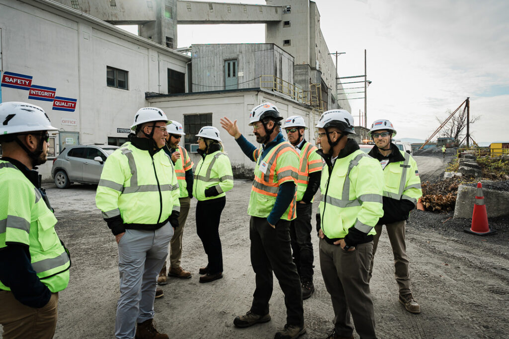 Group of Tilcon team members in safety gear during outdoor facility tour with Safety Integrity Quality signs visible