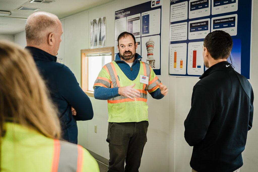 Tilcon site manager in high-visibility safety vest explaining quarry operations to leadership group
