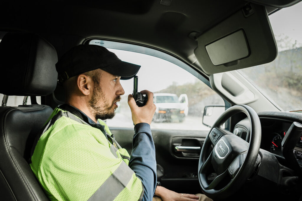 Tilcon worker in safety vest using two-way radio while in vehicle at Clinton Point Quarry