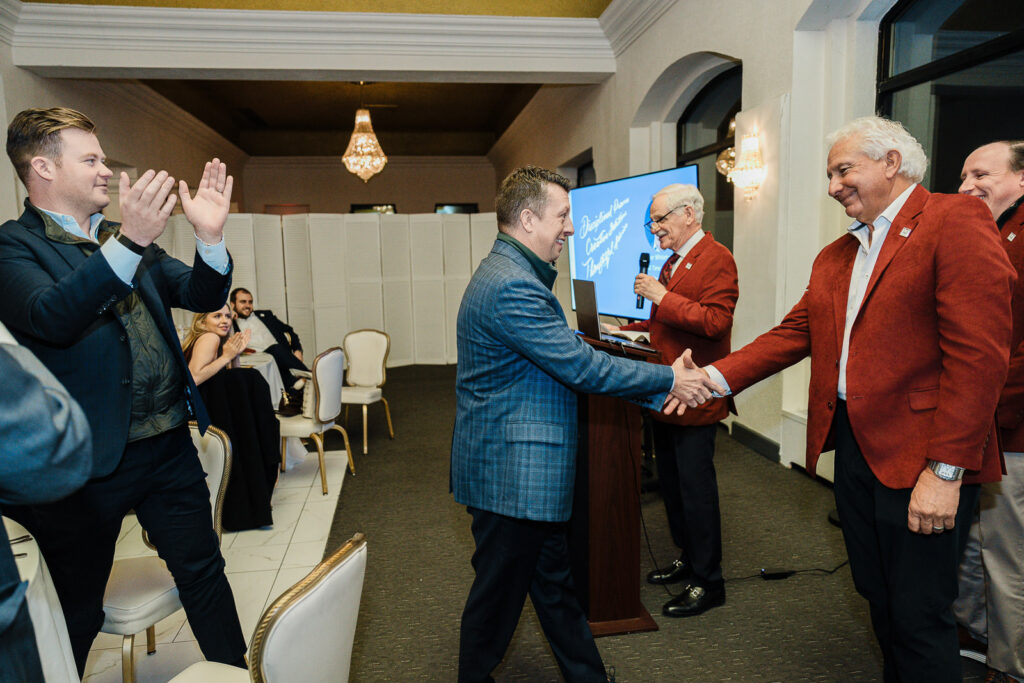 Professional handshake during corporate award presentation captured by Alex Kaplan Photography