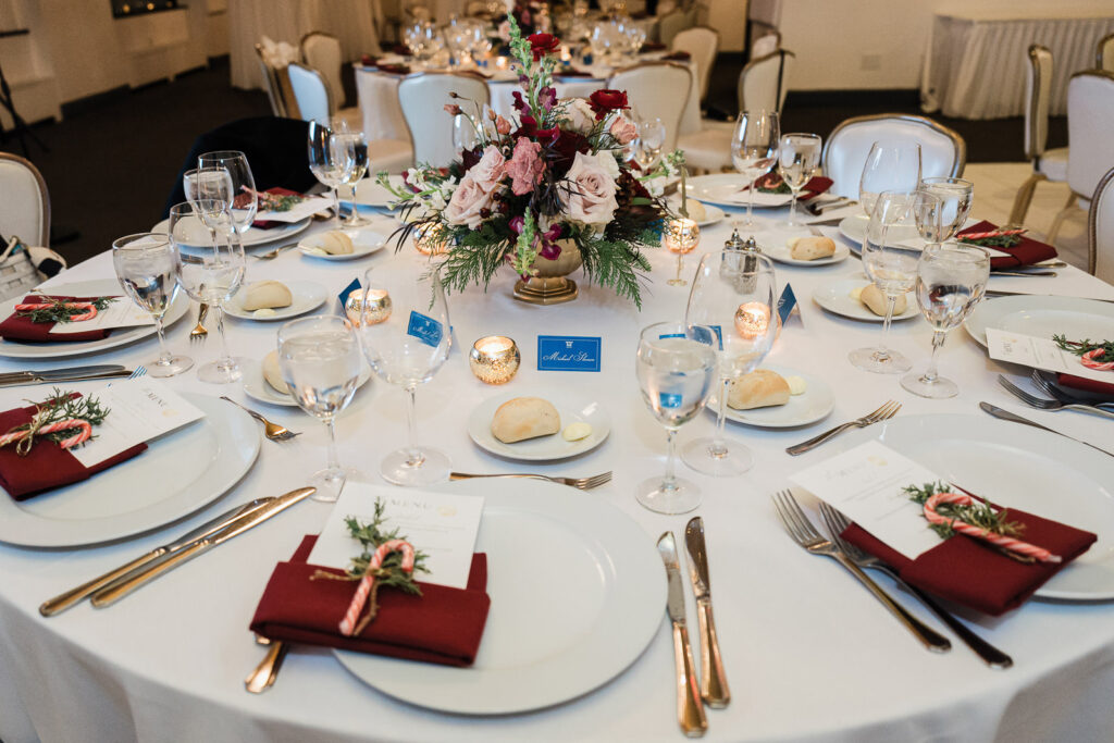Elegant table centerpiece with roses and burgundy napkins at corporate awards dinner by Alex Kaplan Photography