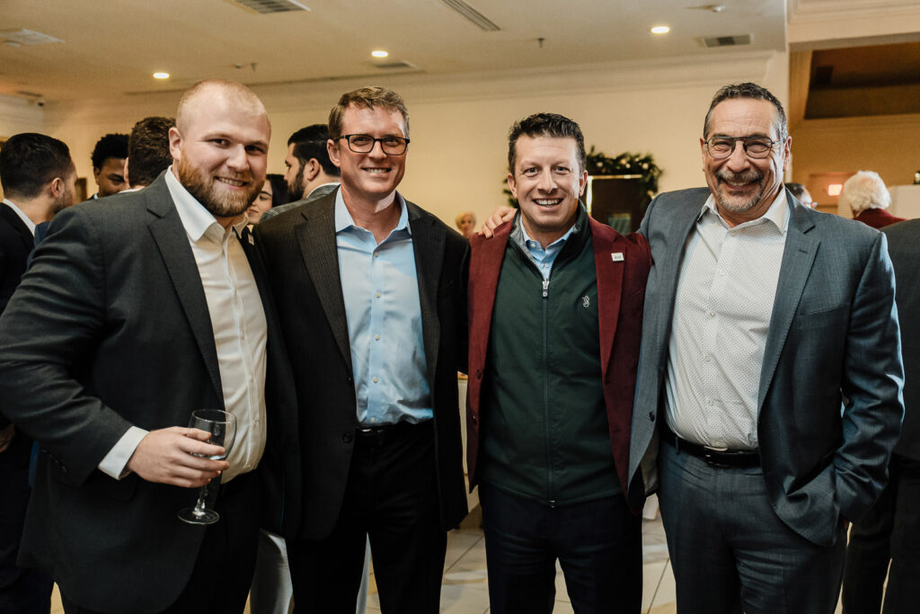 Corporate team members group photo during awards dinner event photographed by Alex Kaplan