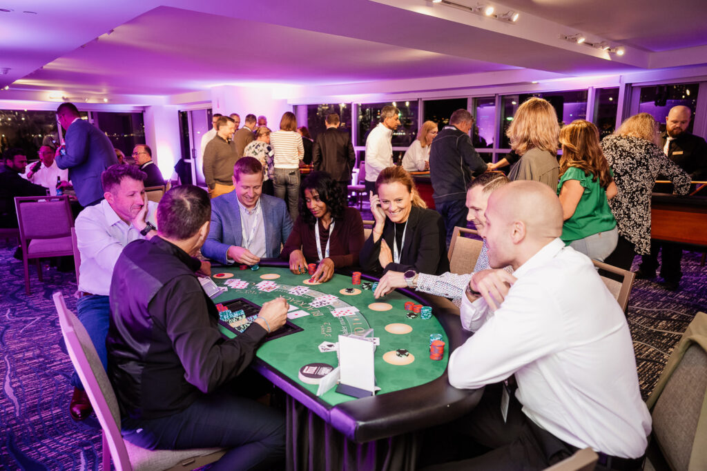 Professionals laughing at poker table by Alex Kaplan