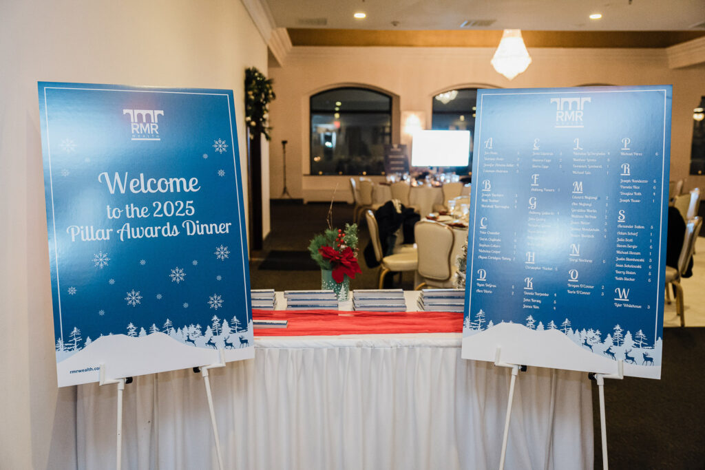 Welcome signage and seating chart for RMR Wealth Builders 2025 Pillar Awards Dinner photographed by Alex Kaplan at The High Lawn