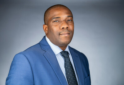 Professional woman in blue suit business headshot with natural smile and proper posing demonstrating expert direction in Northern New Jersey portrait studio