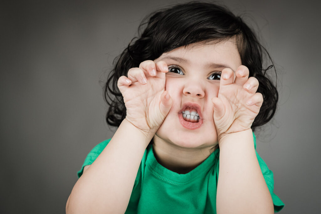 Child actor headshots NJ toddler playful expression range green shirt