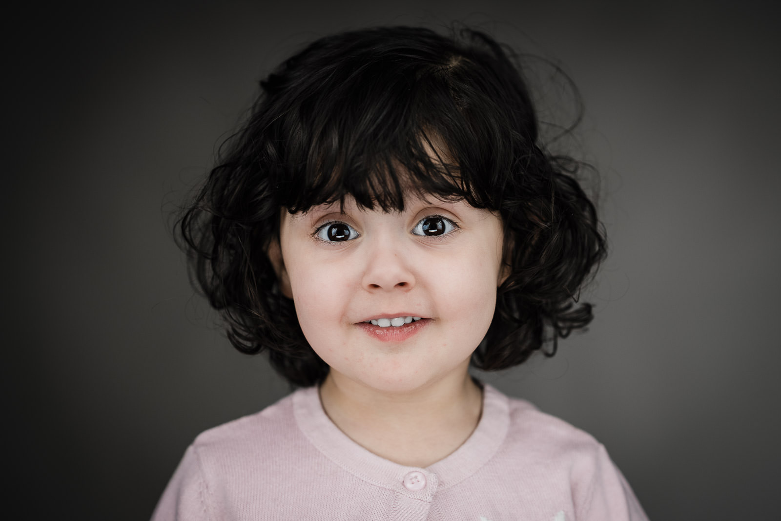Child actor headshots NJ toddler subtle smile pink cardigan gray background