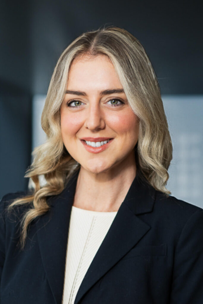 Professional executive headshot with high-contrast dark blue background creating authoritative presence