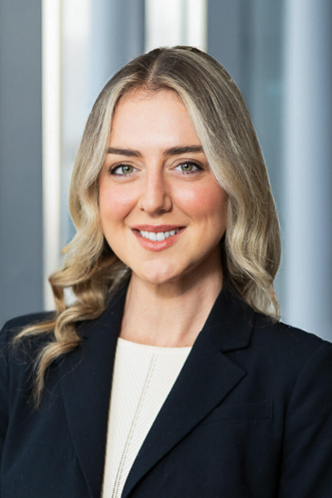 Professional headshot with soft blue architectural columns creating warm corporate atmosphere