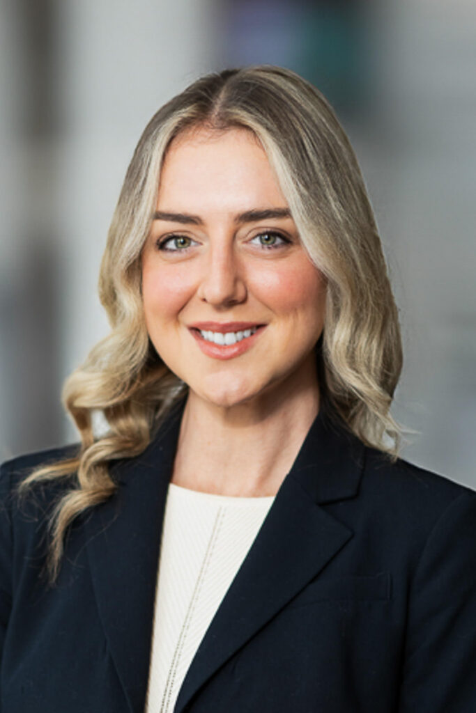 Executive headshot with soft blurred corporate office background for professional warmth