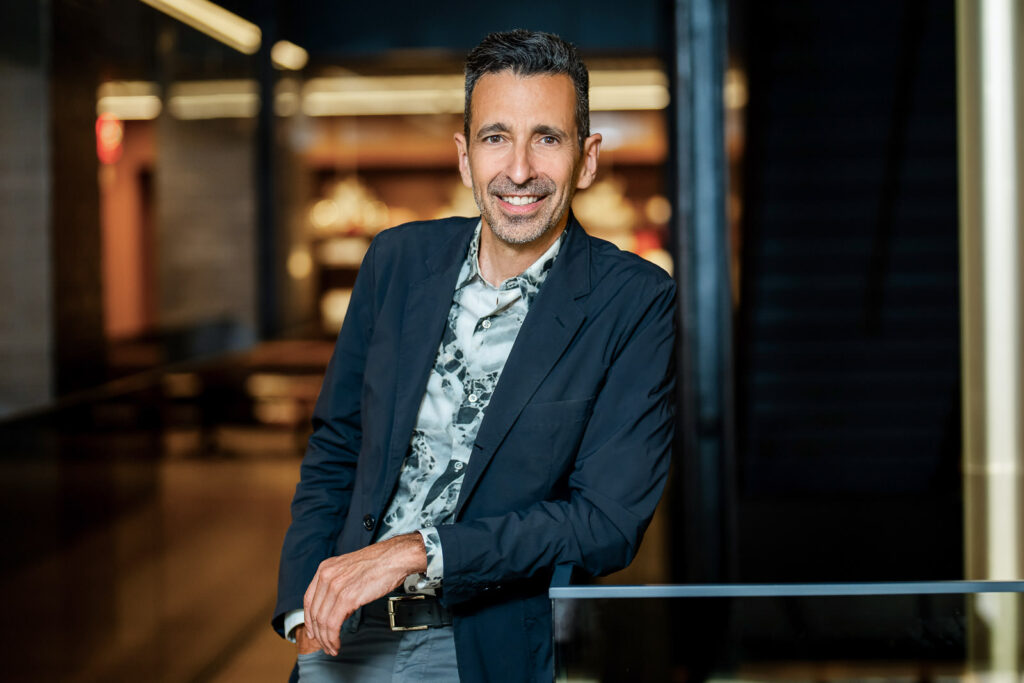 Male executive in dark blazer with patterned shirt in environmental business portrait New York City office