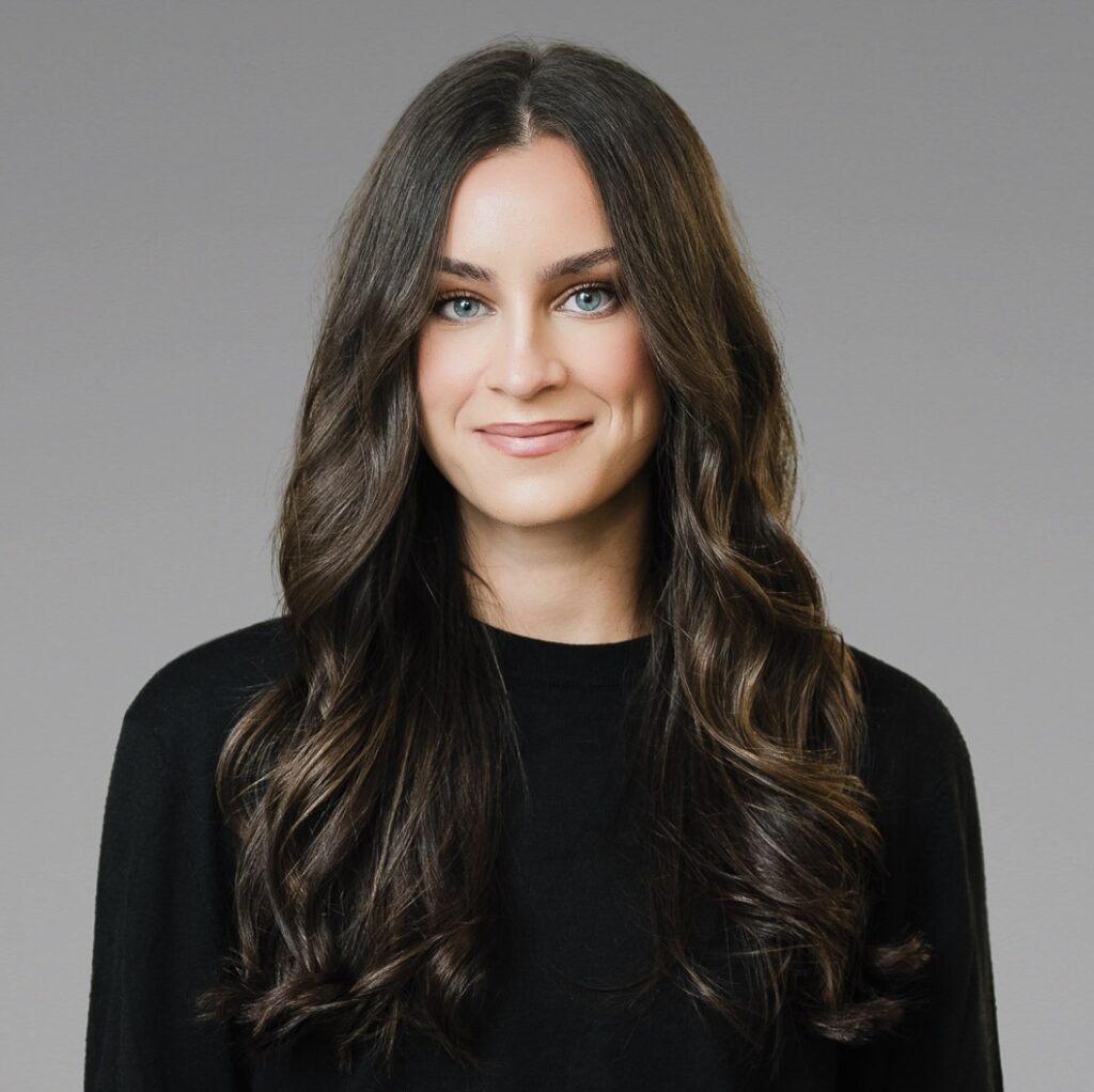 Graduate school application headshot of young woman in black top on neutral gray studio background — Northern New Jersey