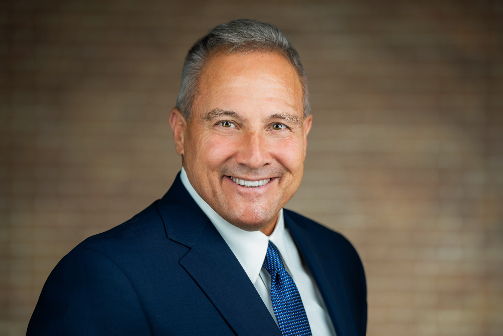 Corporate team headshot of smiling man in navy suit and blue tie NJ firm