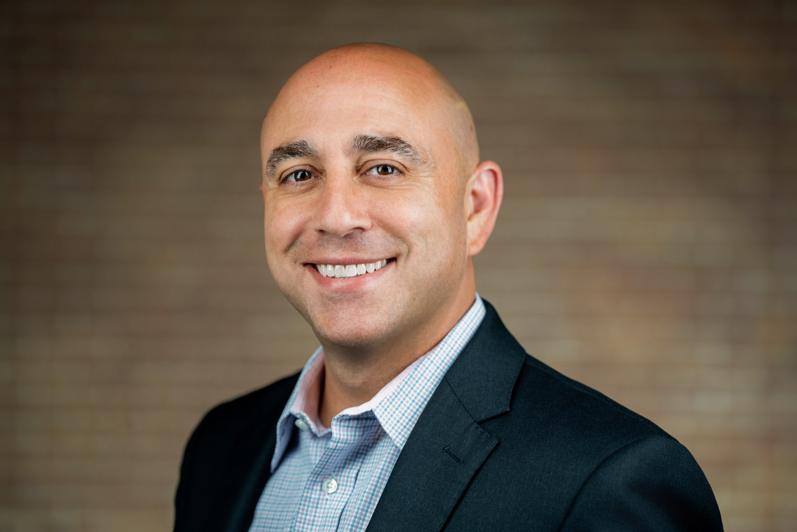 Corporate headshot of bald man in dark blazer light gingham shirt NJ corporate team