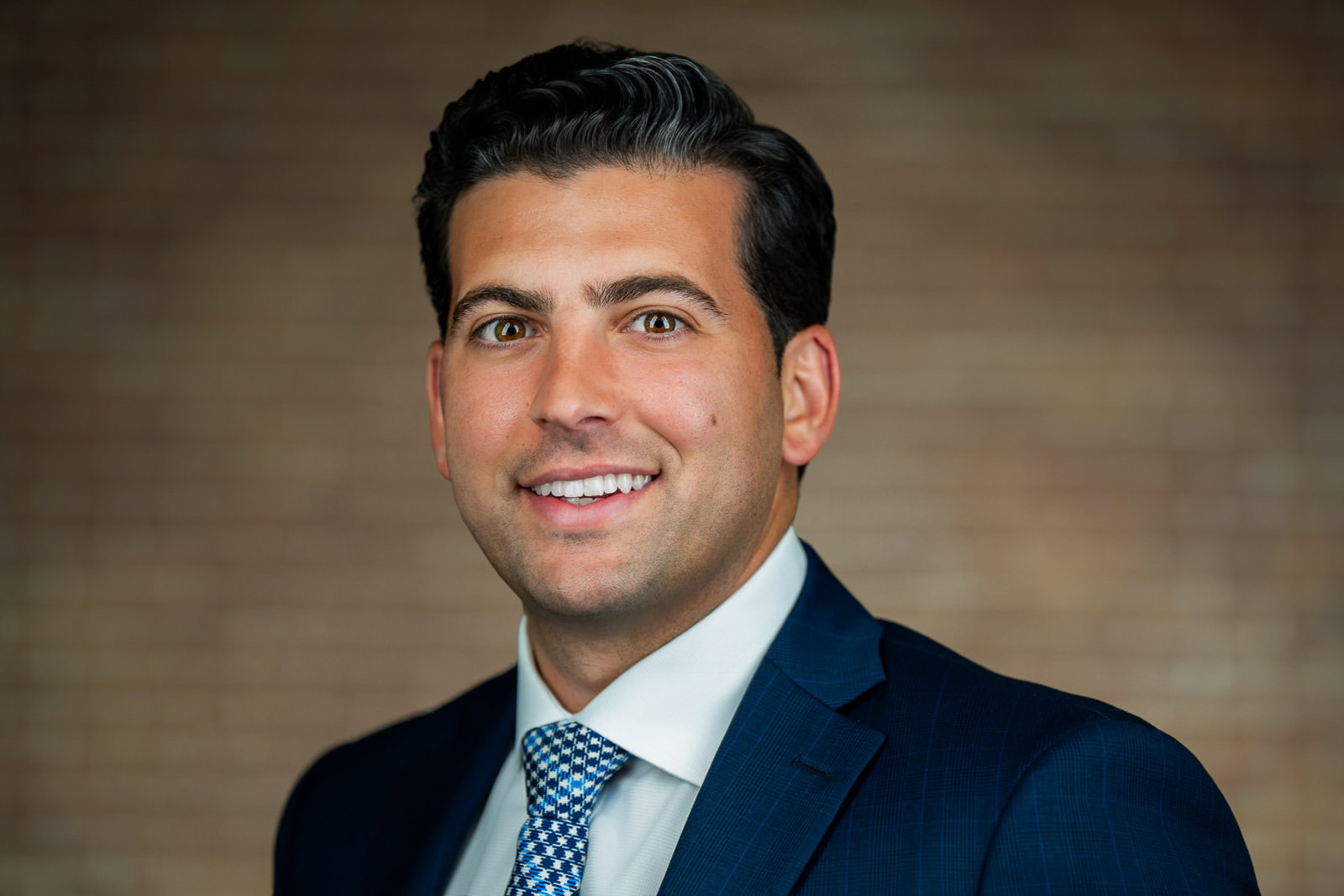Corporate team headshot of young man in navy suit blue patterned tie NJ firm