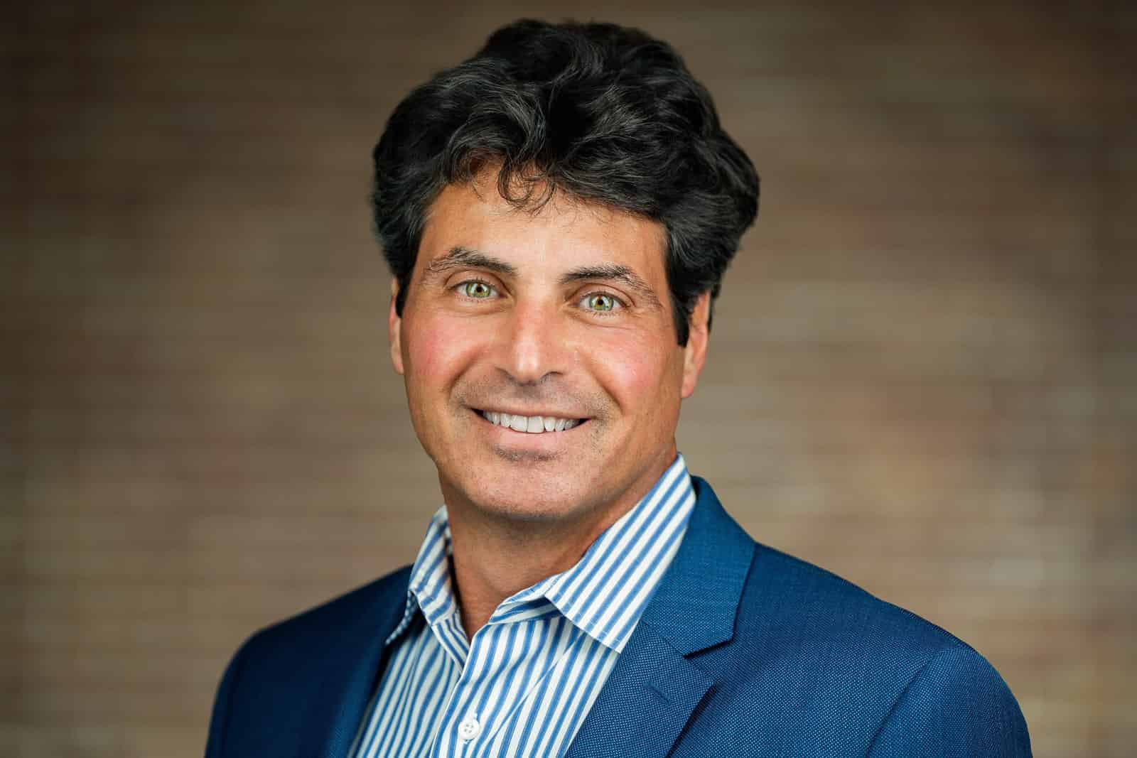 Professional headshot of man in blue blazer white striped shirt NJ corporate team