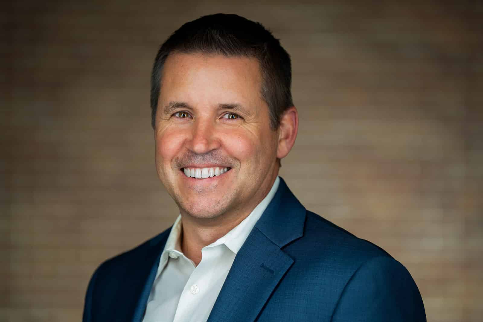 Corporate headshot of man in blue blazer white shirt big smile NJ on-location session
