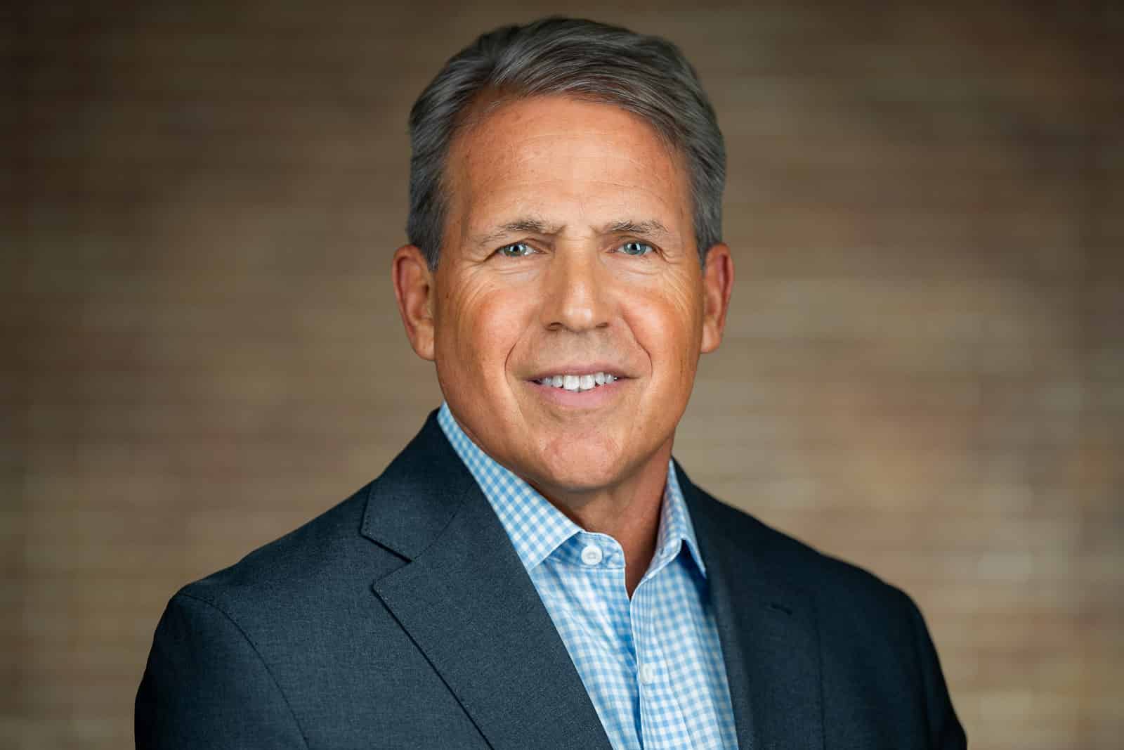 Professional headshot of senior executive in charcoal blazer gingham shirt NJ corporate team