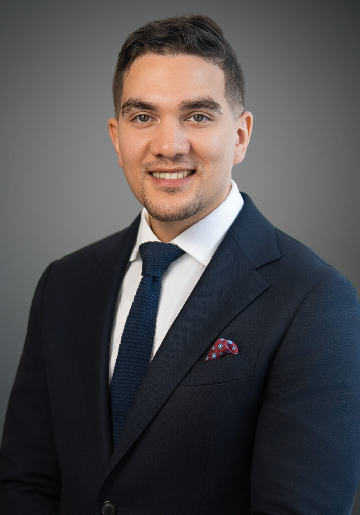 Professional executive headshot of Christian Rosa in a navy suit