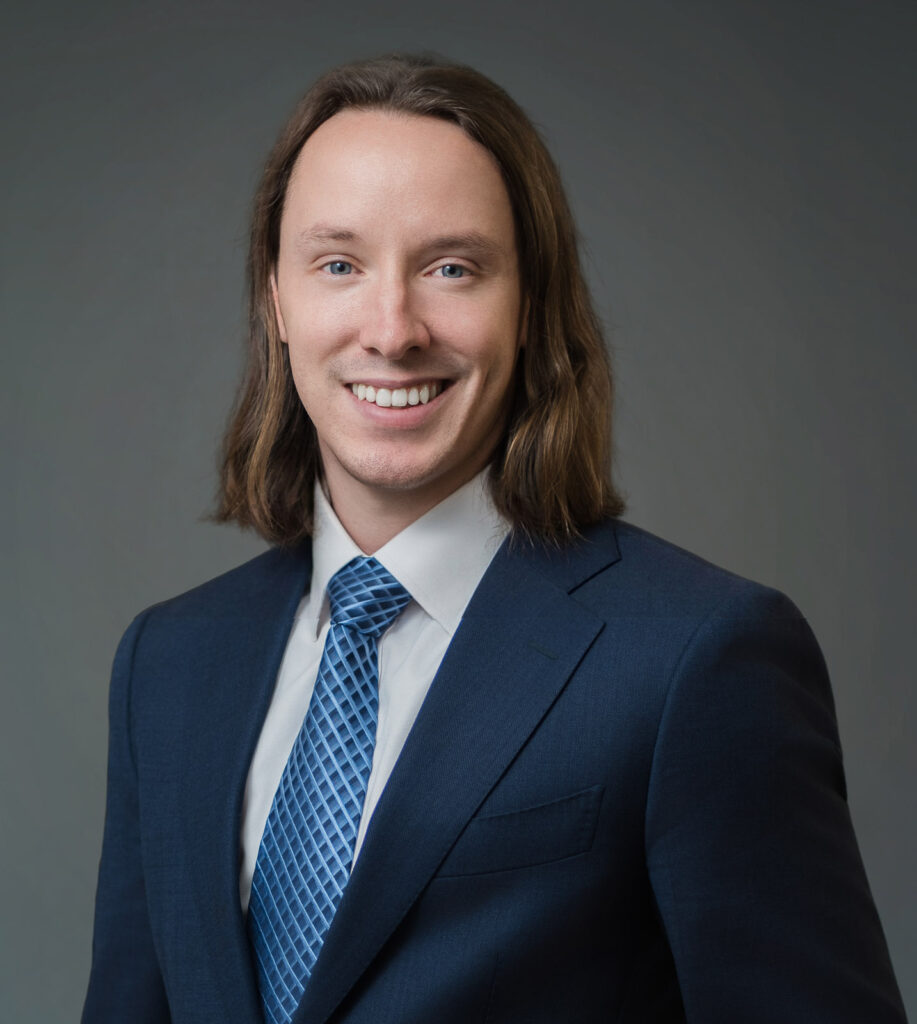 Corporate headshot of a professional man with long hair wearing a navy suit Northern New Jersey studio