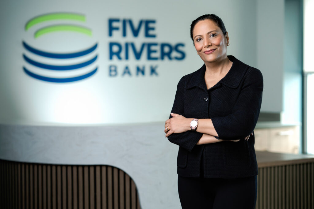 Confident corporate headshot of woman in black blazer with arms crossed at Five Rivers Bank