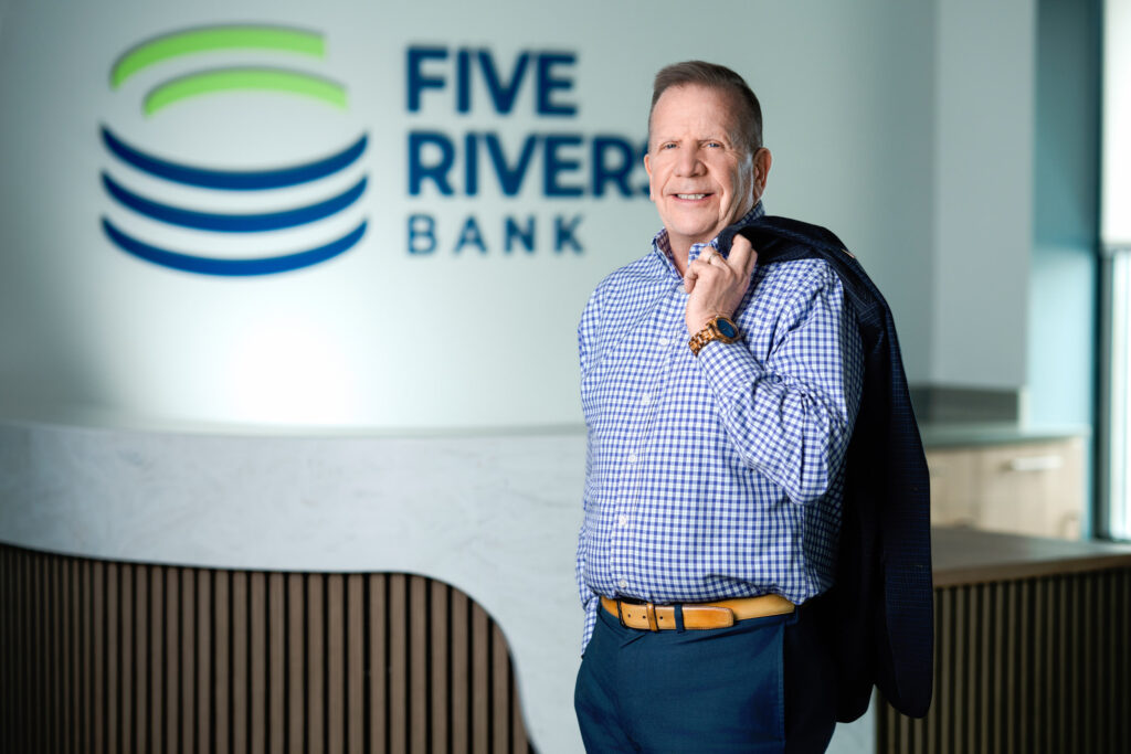 Corporate headshot of business professional holding jacket in Five Rivers Bank lobby