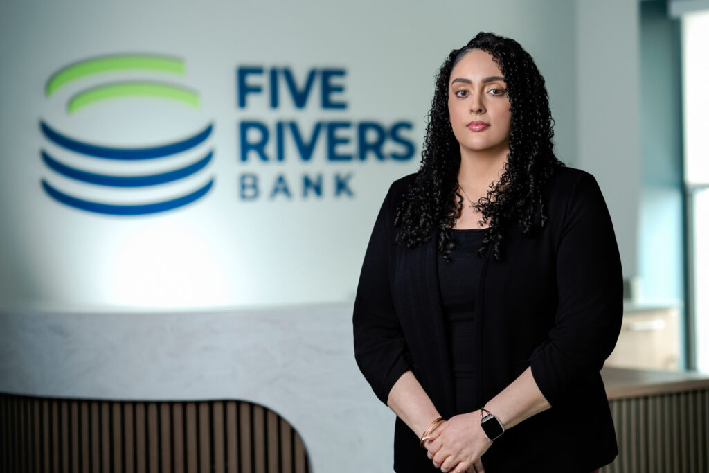 Professional headshot of woman with curly dark hair in black blazer at Five Rivers Bank