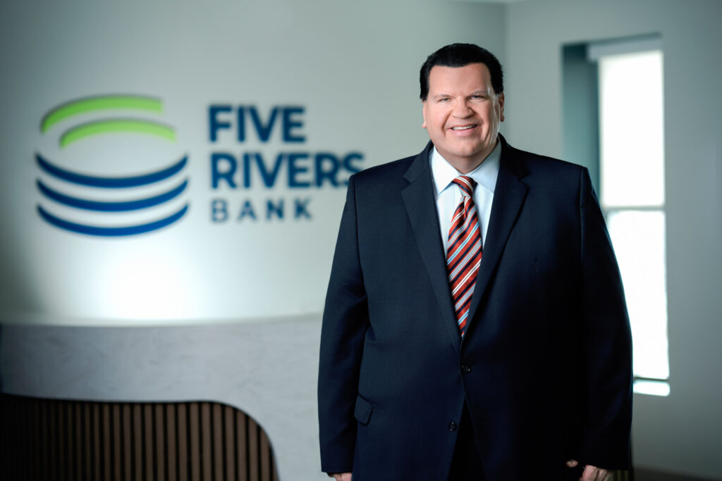 Professional corporate headshot of man wearing red striped tie and dark suit