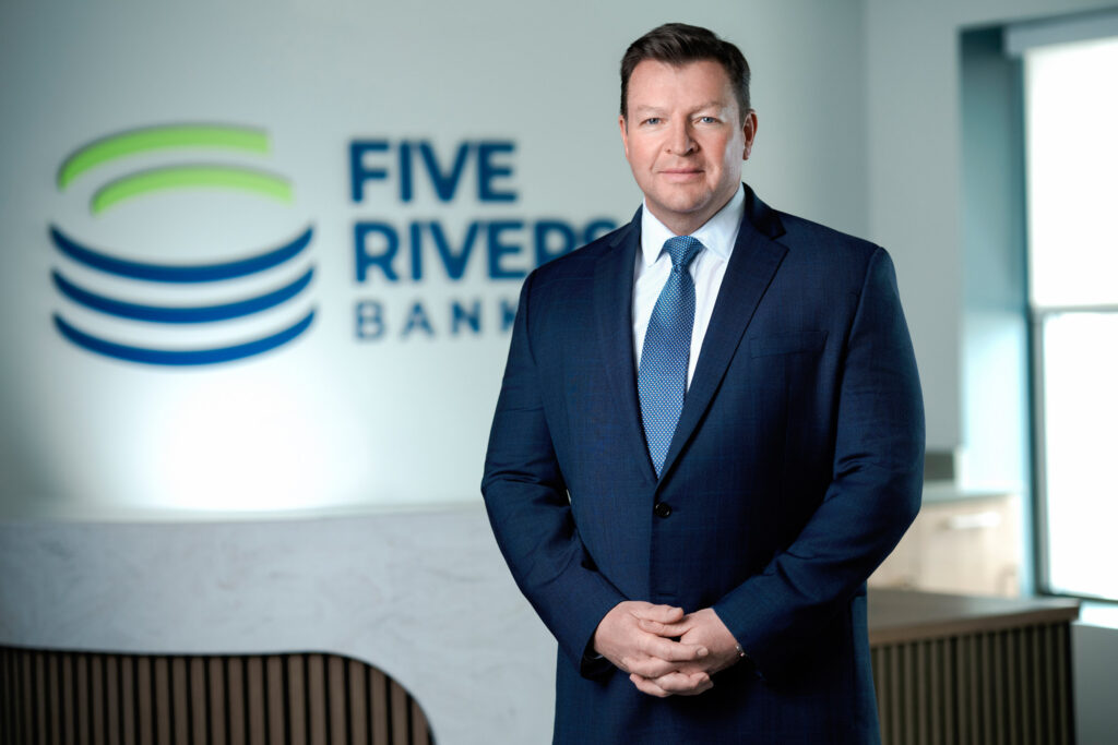 Senior executive corporate headshot in navy suit with confident and polished expression