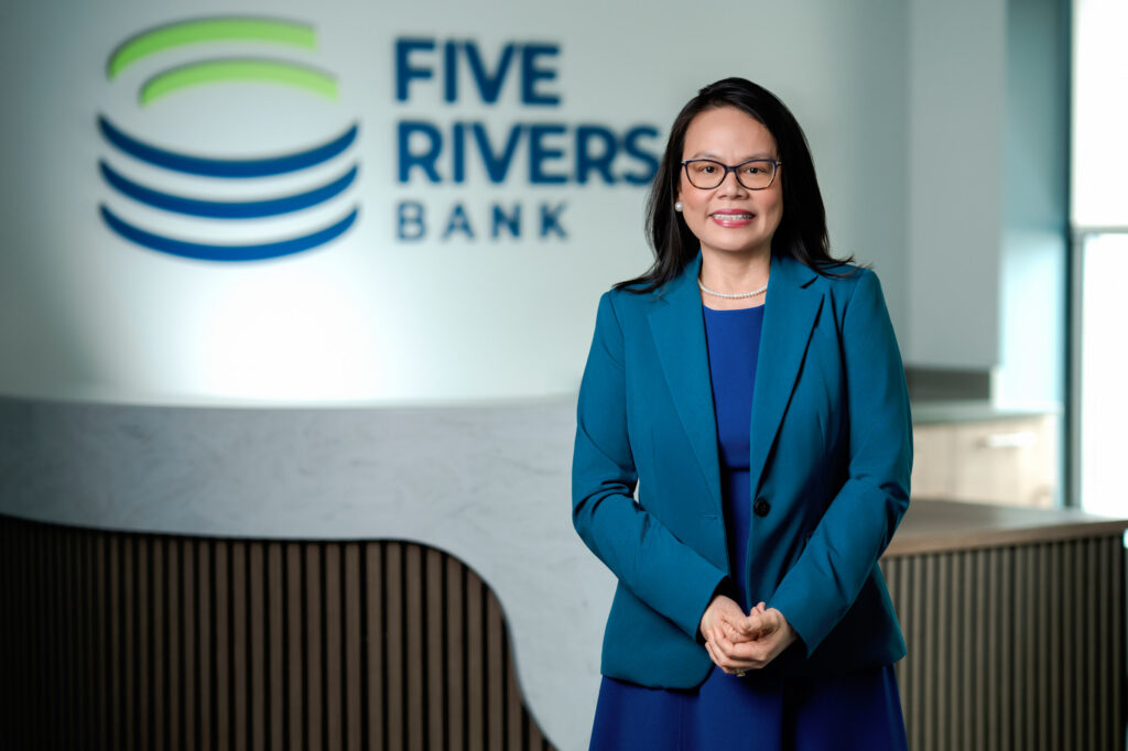 Corporate headshot of woman with glasses wearing teal blazer at Five Rivers Bank