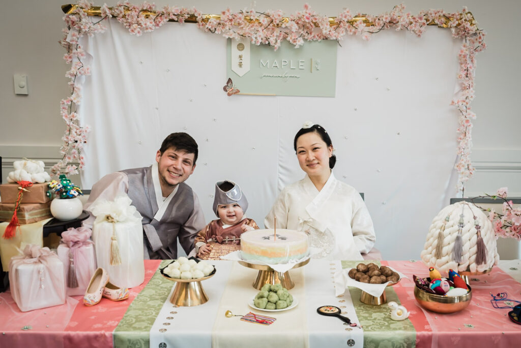 Family portrait at Korean first birthday Dol table with traditional foods and Maple birthday sign in New Jersey