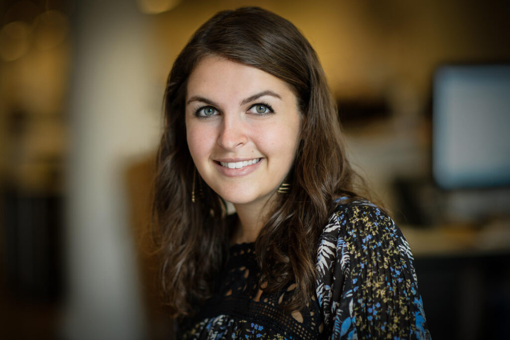 LinkedIn headshot example woman dark wavy hair floral top gold earrings warm smile NJ
