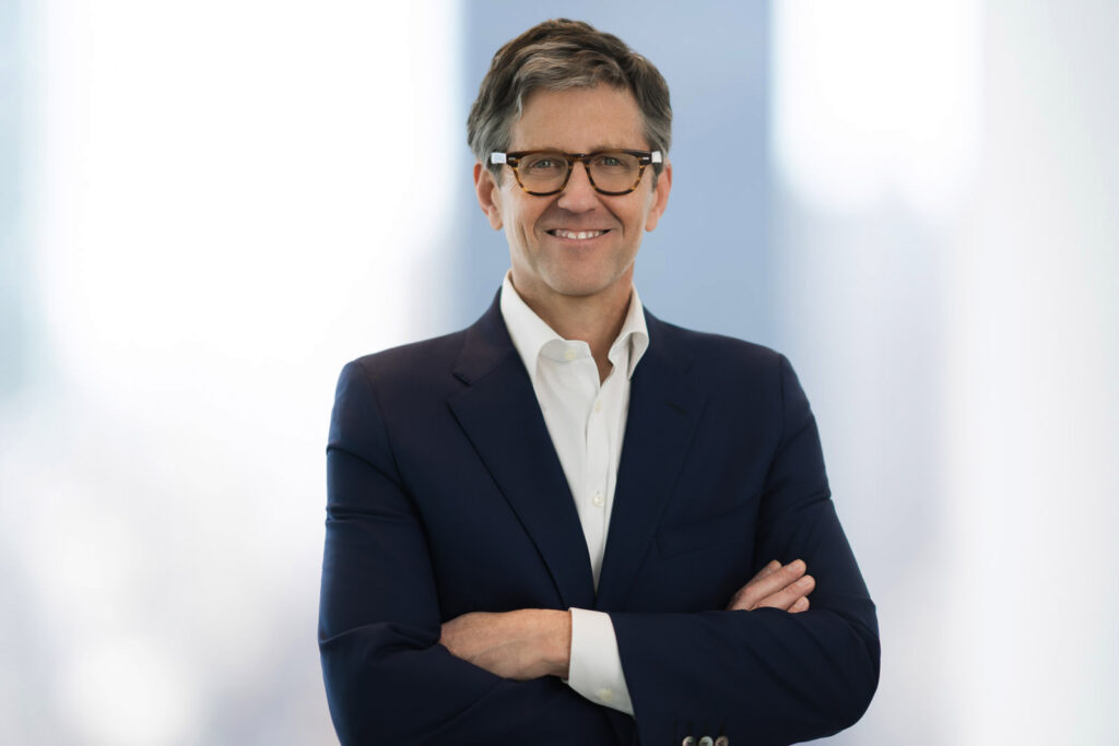 Confident male financial advisor headshot with arms crossed and direct eye contact in navy blazer New Jersey