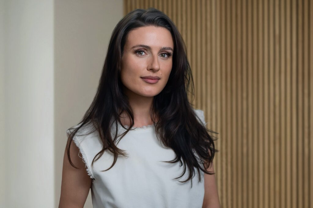 Relaxed, confident professional headshot with natural engaged eye contact in a modern New Jersey setting