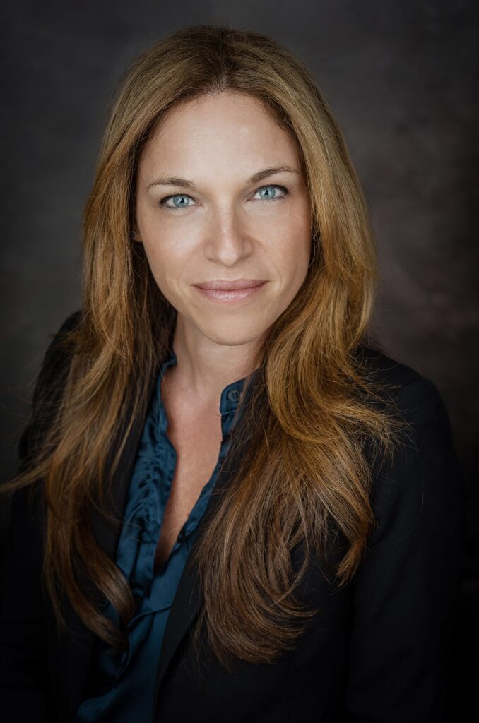 Professional headshot of a female executive smiling with her eyes, showing warmth and bright catchlights, by Alex Kaplan in New Jersey